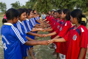 Nepal National Secondary School, Siyarahi Settlement: Girls shake hands after a game of football on the village field