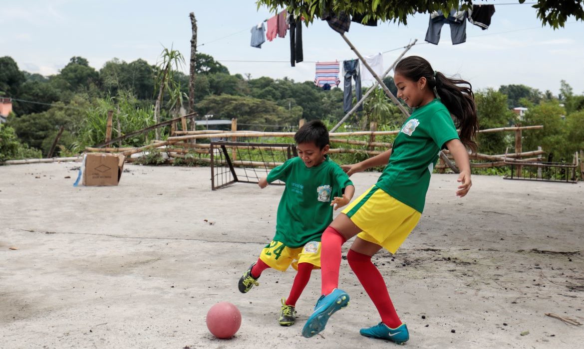 two children playing football together
