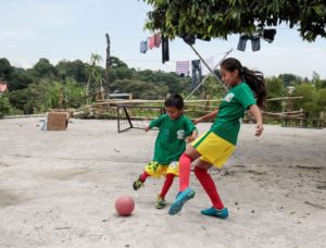 two children playing football together