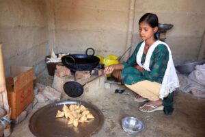 a girl frying samosas